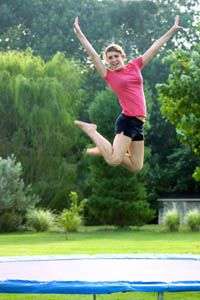 jeune fille sautant sur son trampoline de jardin