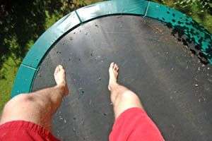 trampoline rond vue du dessus avec les pieds du sauteurs