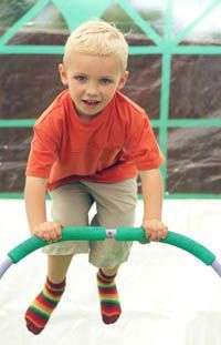 enfant sautant sur mini-trampoline avec barre de maintient